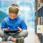 Child Listening to Headphones in the Library